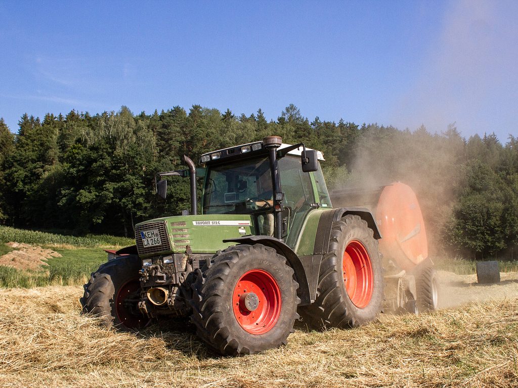 Traktor bei der Heuernte im Staub
