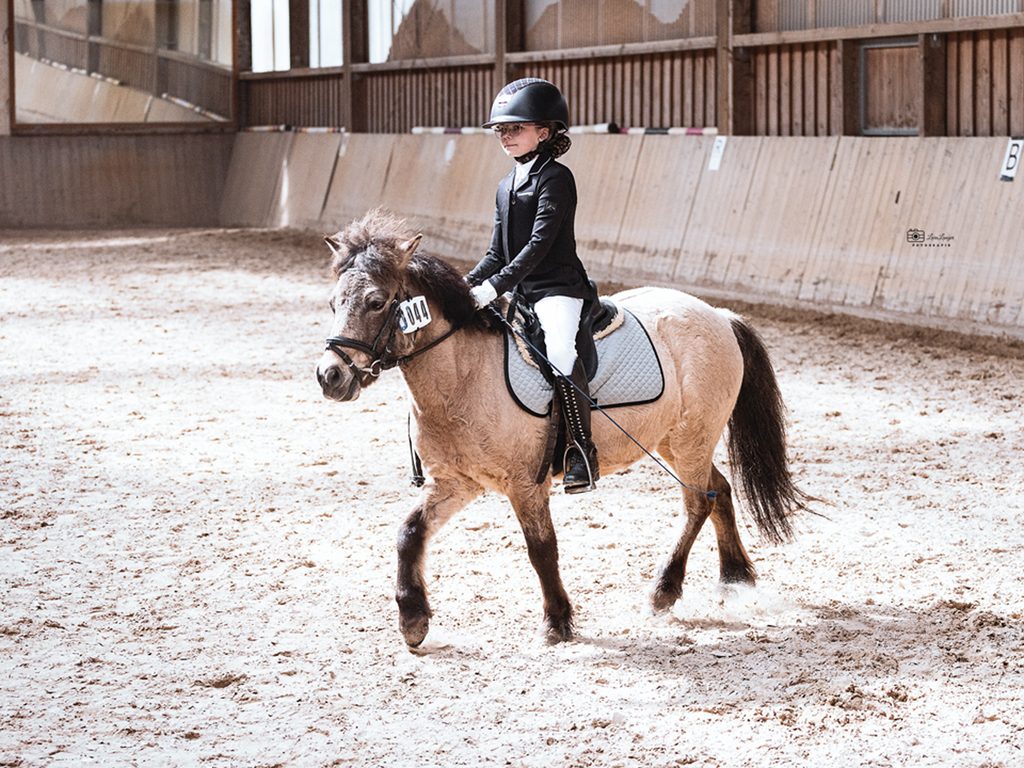 Junger Reiter mit Pony in Bewegung
